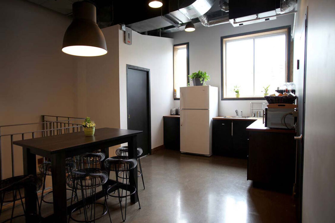 Espace cuisine simple au travail, équipé d'une table pour les repas.