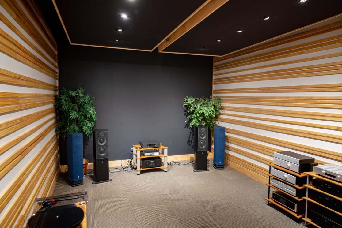 Un endroit d'enregistrement avec des murs sonorisés en noir et des accents de bois.