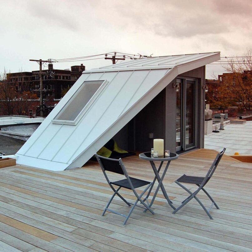 Terrasse sur le toit avec un petite table et deux chaises.