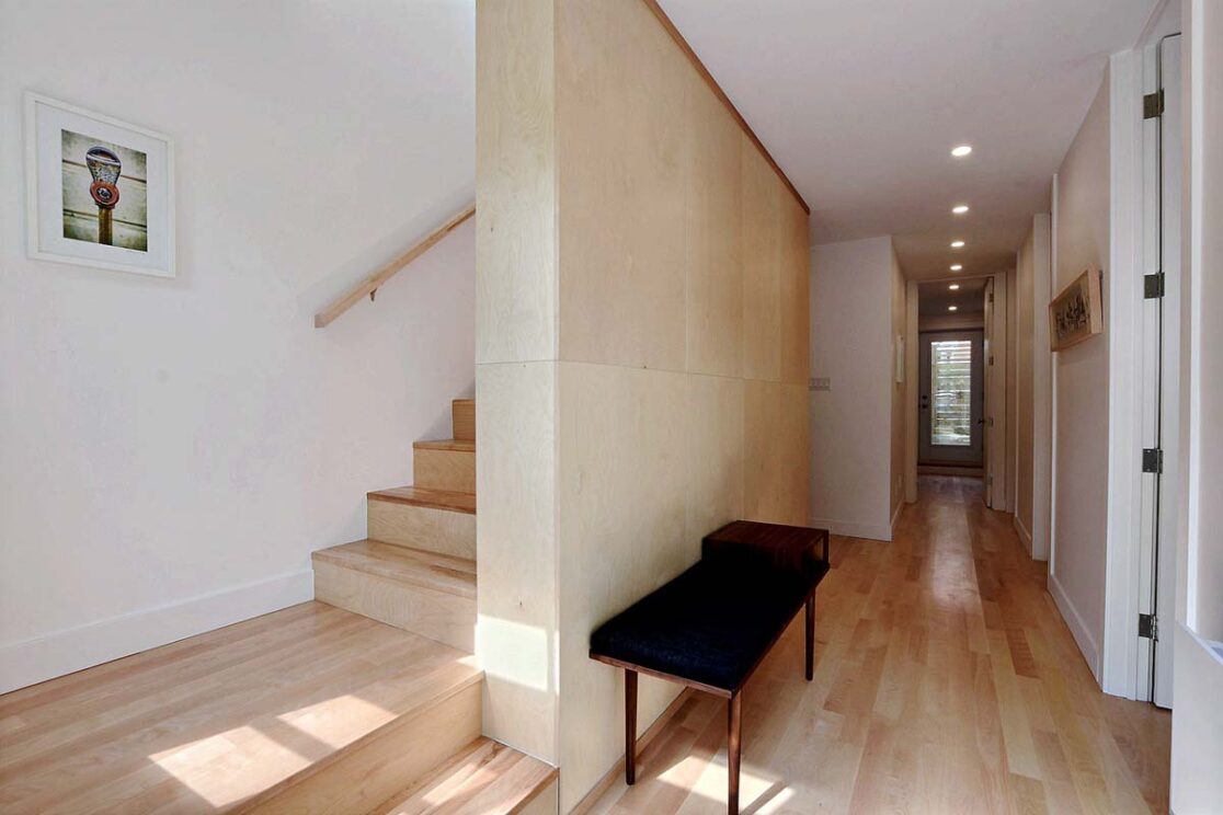 Corridor avec un banc d'entrée avec vue des escaliers pour monter.