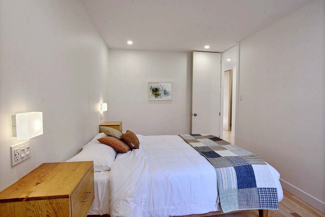 Une chambre avec un lit agrémenté d'accents orangés.