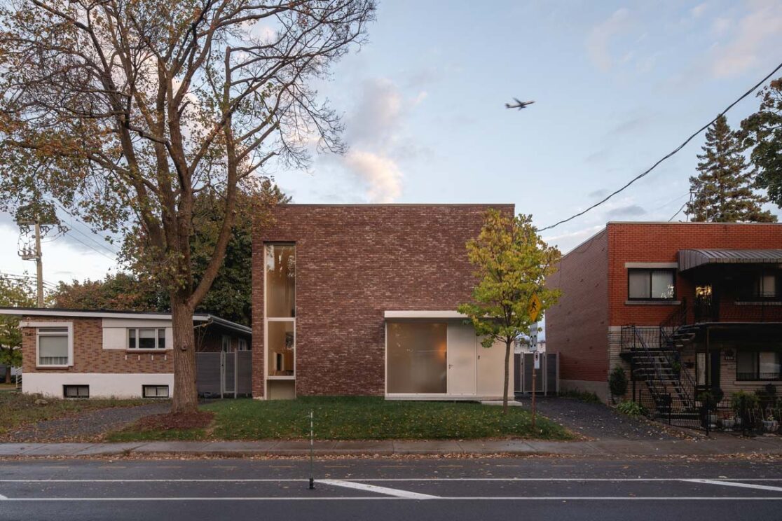 Vue sur la maison cubique en brique avec de grandes fenêtres.