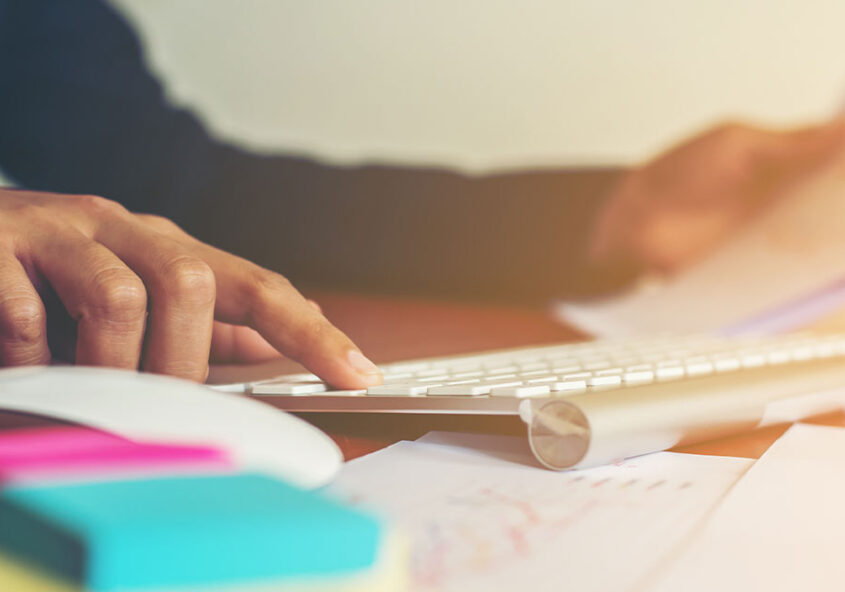 Un homme devant son clavier en train de planifier ses finances.