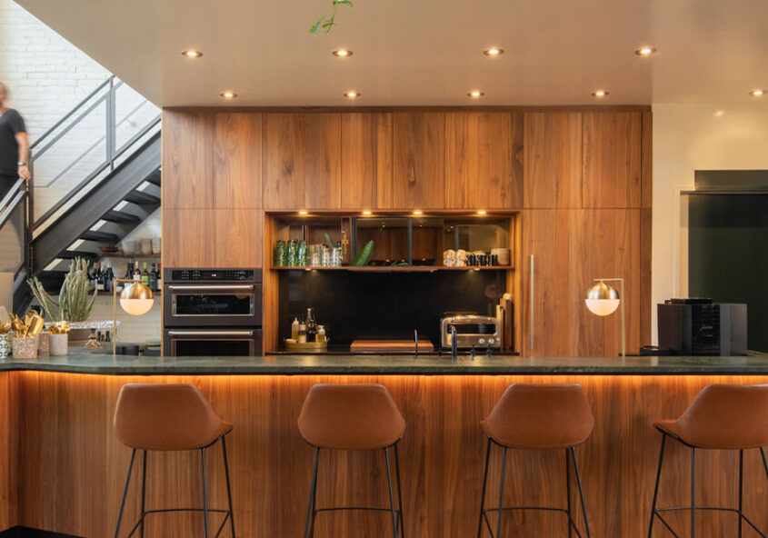 Un bar accueillant, éclairé et doté de plusieurs chaises, avec un escalier menant à l'étage.