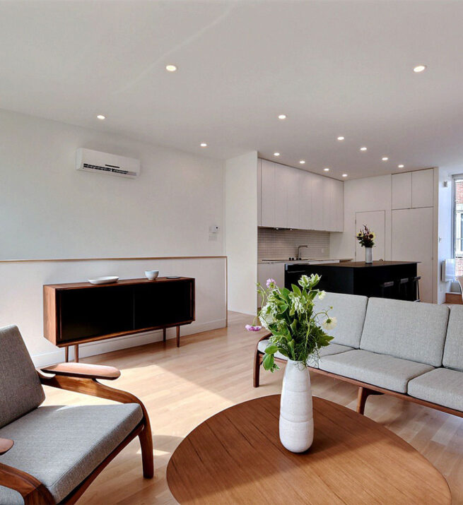 Salon avec une belle table et une cuisine située au fond de la pièce.