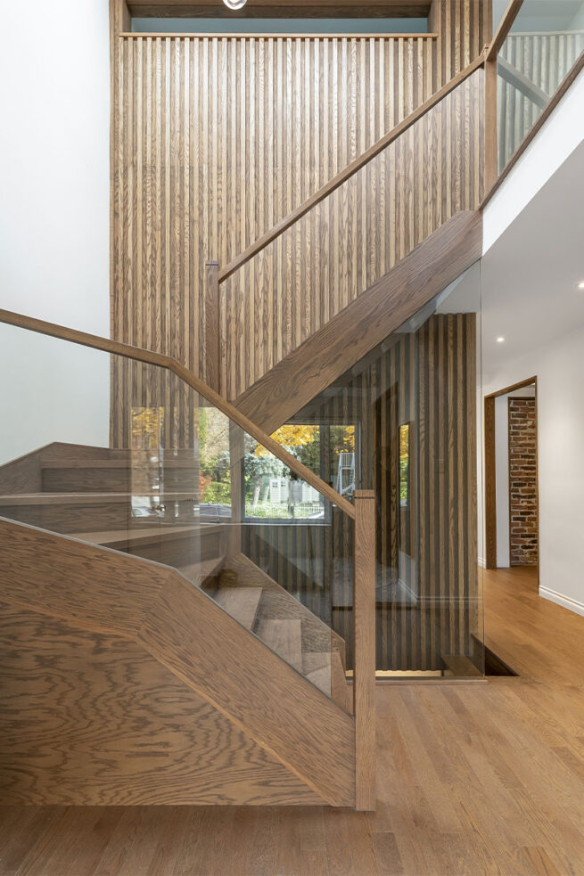 Des escaliers en bois accompagnés d'un mur accentué également en bois