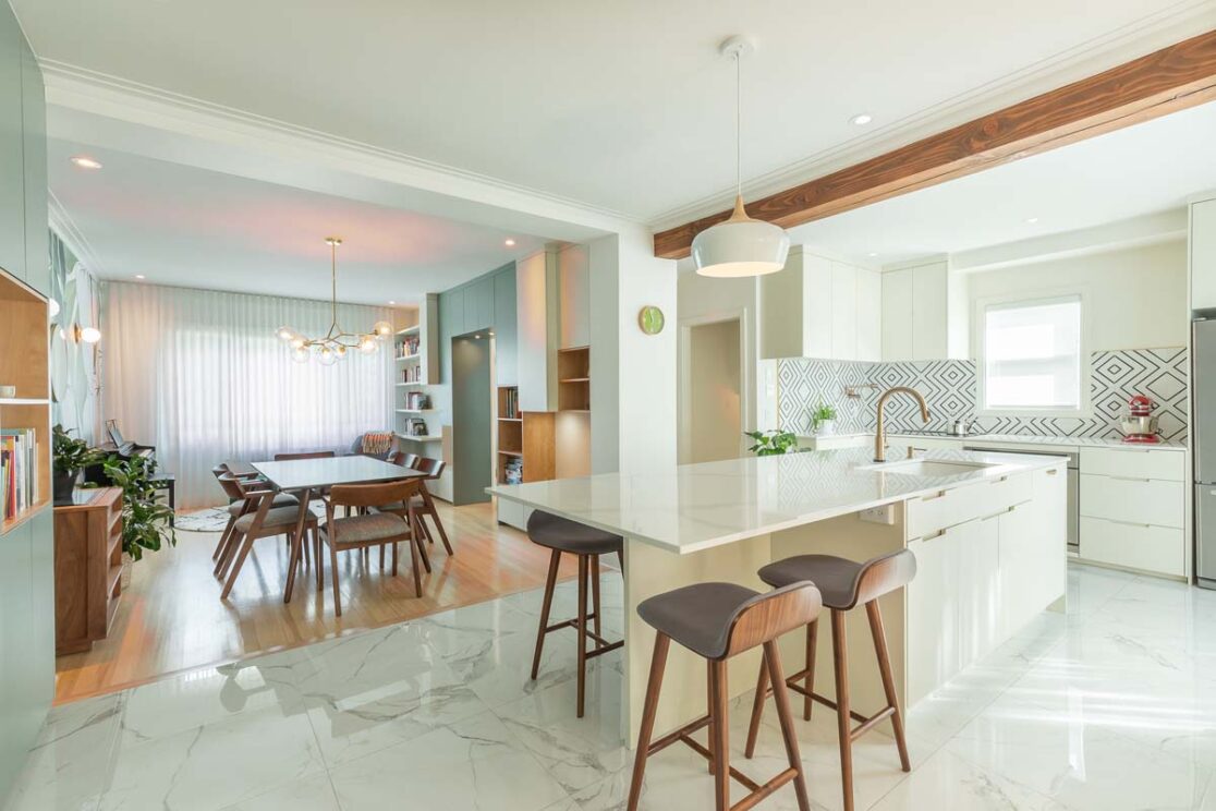 Cuisine avec des armoires blanche avec vue sur la salle à manger.