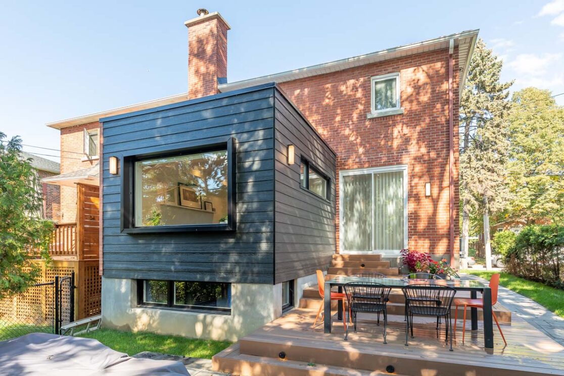 Cour arrière avec nouvelle extension de la maison et un endroit pour manger dehors.