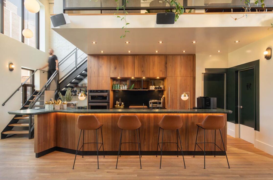 Un bar accueillant, éclairé et doté de plusieurs chaises, avec un escalier menant à l'étage.