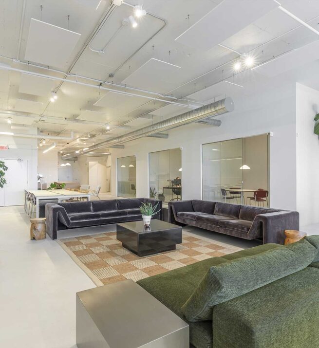 Espace commun contemporain avec des canapés et des tables.